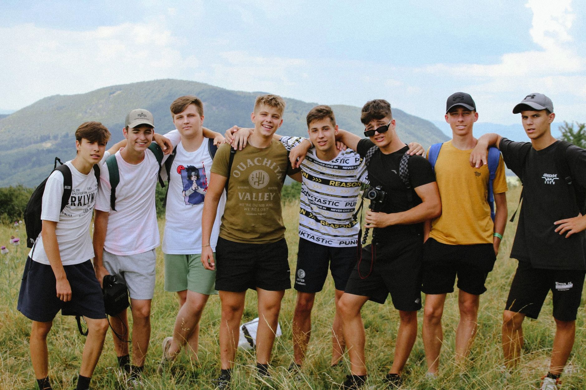 group of young men standing on green grass field