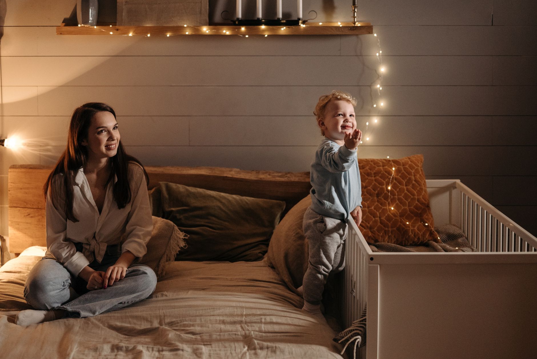 a mother and son on a bed looking up