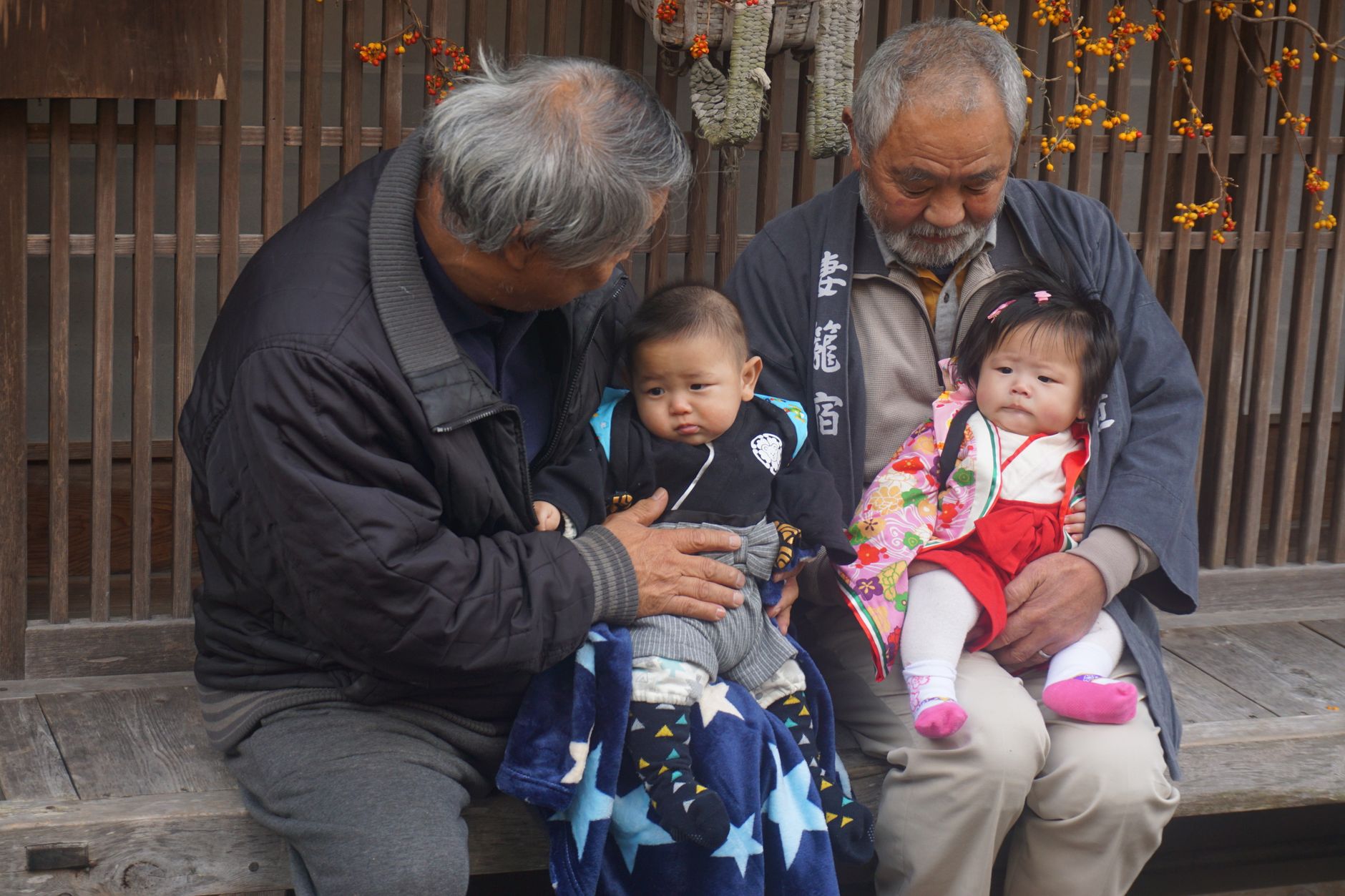 two elderly men carrying a two baby