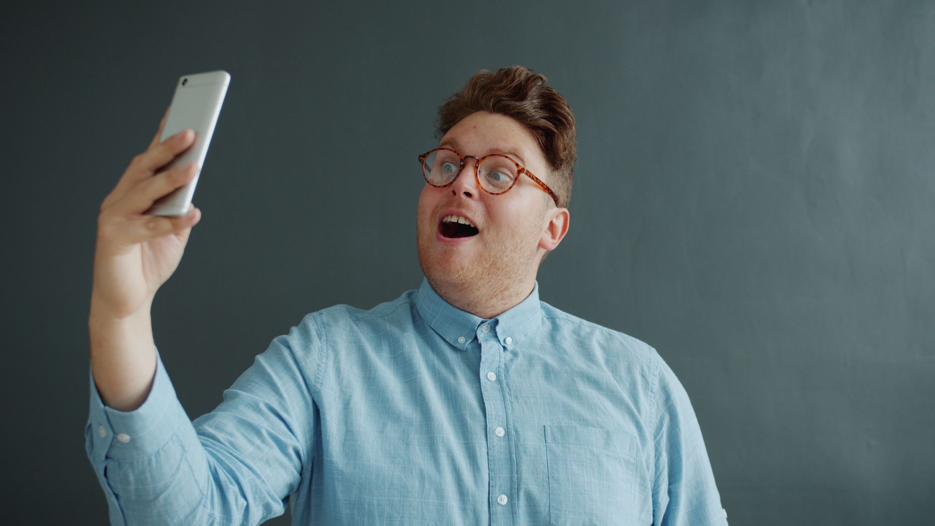 excited man taking a selfie with smartphone